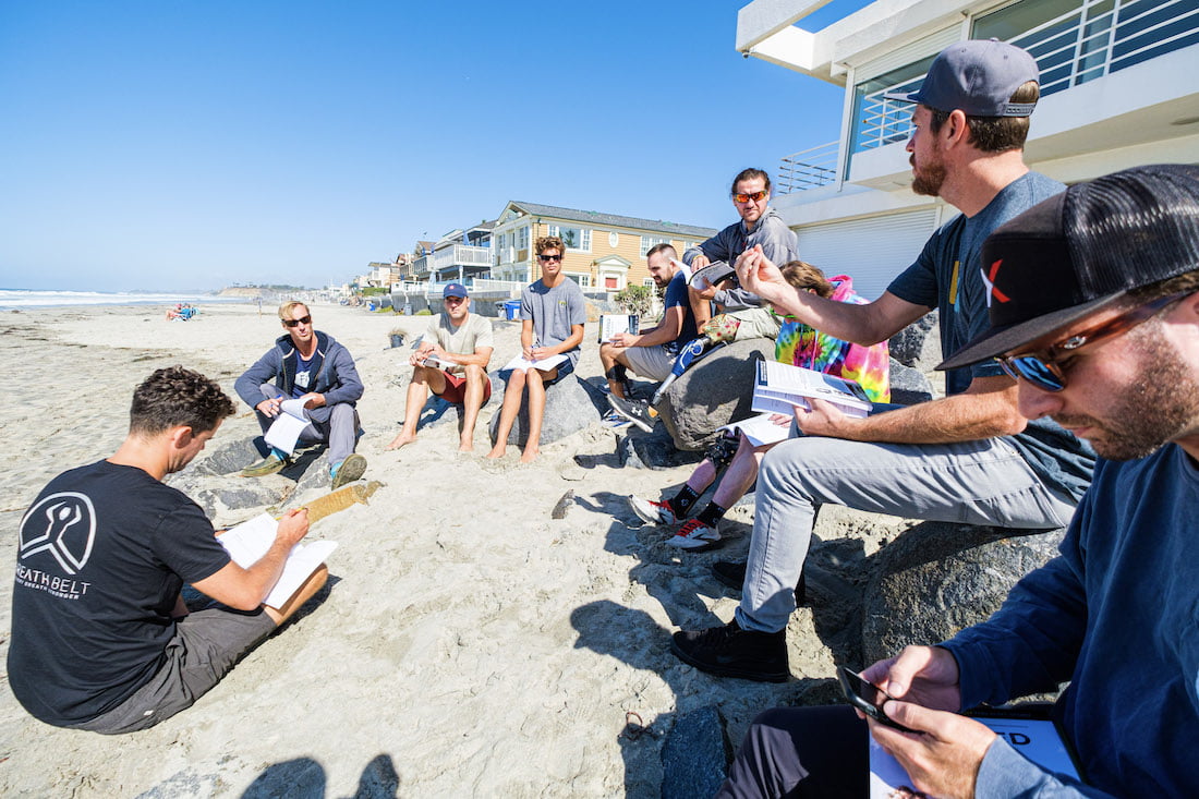 The Forge men during a group session sitting on the beach going through their devotionals and listening to the speaker.