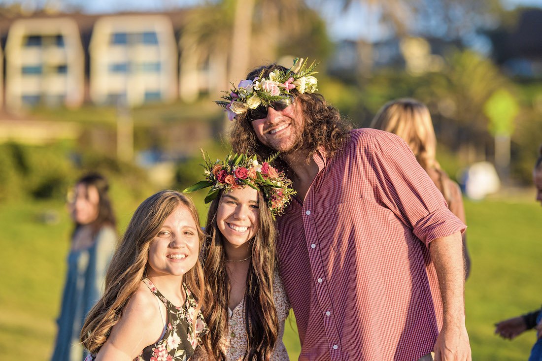 Two Beautifully Flawed retreat attendees with their haku leis and a Forge attendee smile enjoying in afternoon at Powerhouse Park in Del Mar, California.