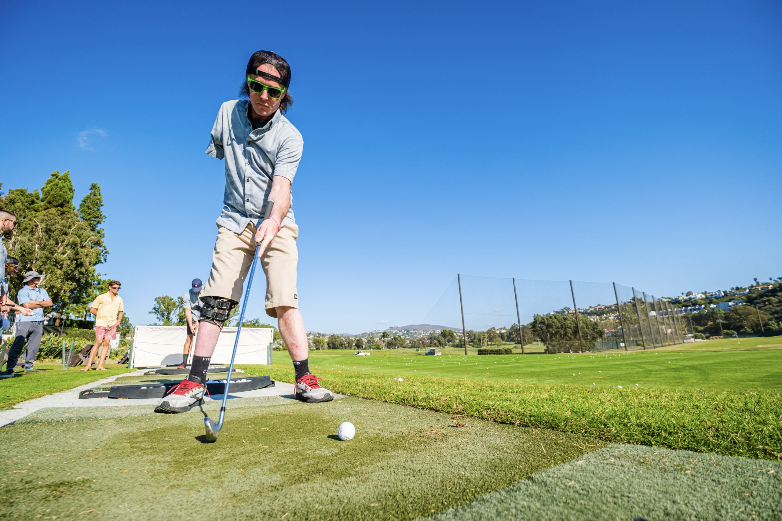 Shane learns how to adaptively golf at the Forge retreat as an arm amputee and gets ready to swing the golf club at the driving range.