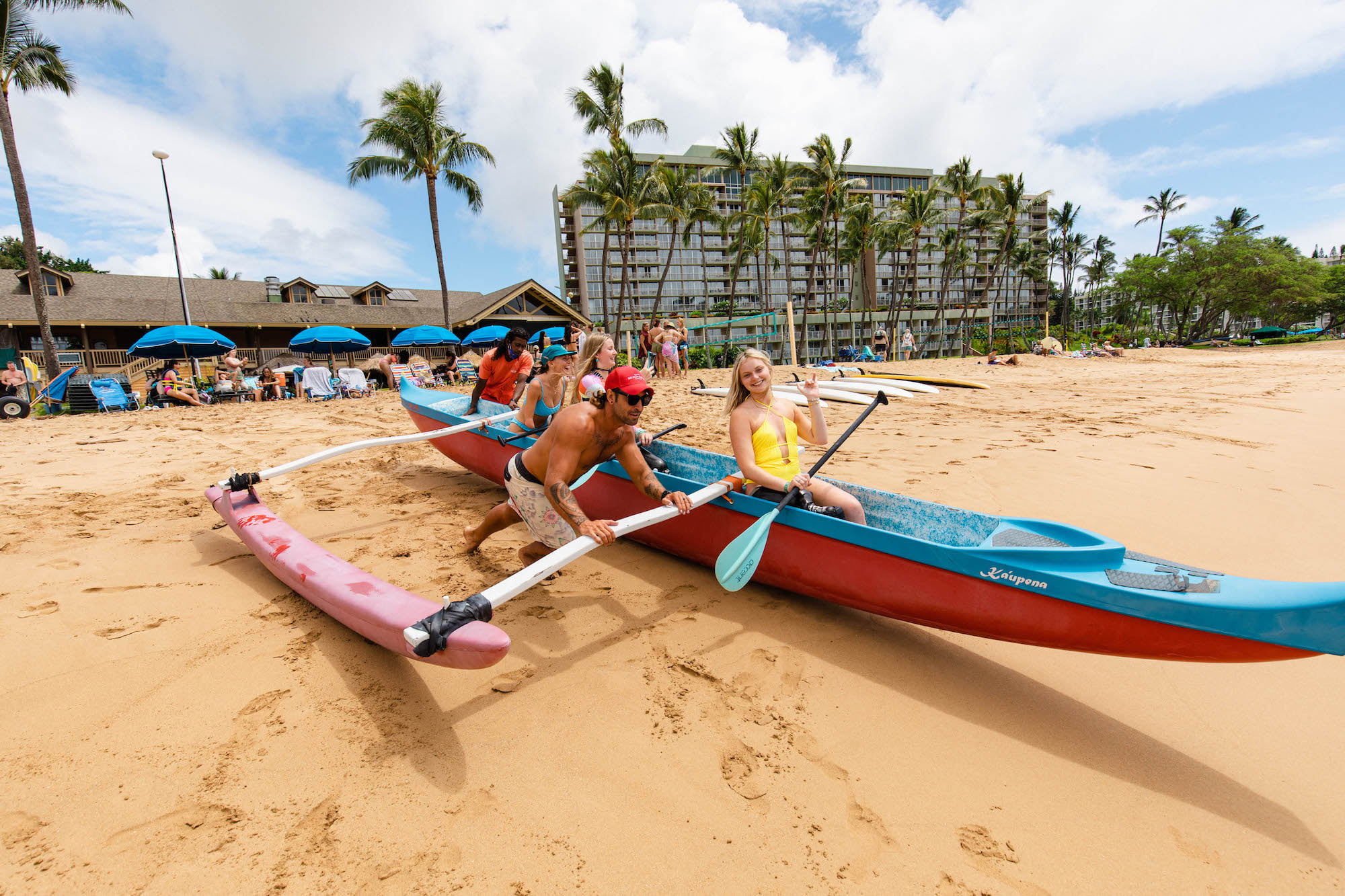 Retreat attendees getting pushed into the water in their outrigger canoe