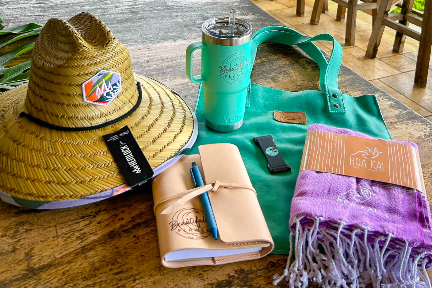 Gift Bag items from Hemlock Hat Co., Rustico, YETI, Love 41, LoveHandle, and Hoa Kai Surf
