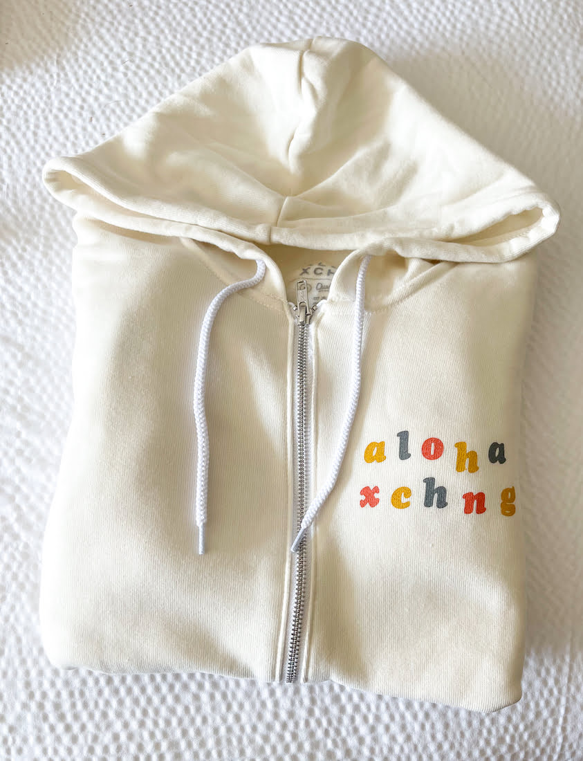 A clothing brand from Kauai Aloha Xchng white zip up hoodie.